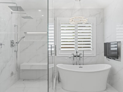 05-DSC04293 Modern bathroom design featuring a freestanding bathtub, glass shower enclosure, marble walls, and stylish fixtures, reflecting high-end remodeling aesthetics.