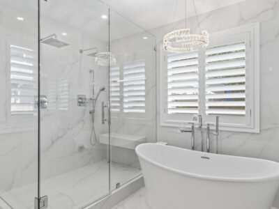 06-DSC04296 Modern bathroom featuring a freestanding bathtub, glass shower enclosure, and elegant marble walls, highlighting stylish design elements for home remodeling.