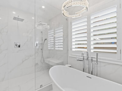 09-DSC04331 Modern bathroom featuring a freestanding bathtub, sleek shower with glass enclosure, marble walls, and elegant lighting fixtures, illustrating luxurious design elements for remodeling projects.