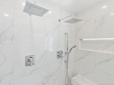 13-DSC04301 Modern bathroom shower featuring sleek marble tiles, contemporary fixtures, and an overhead rain showerhead, emphasizing luxury and design in home remodeling.