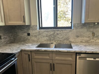 17-Nov 11 2024 08_09pm-Kpcx Kitchen countertop featuring a gray granite surface, double sink, and light wood cabinetry, emphasizing modern design for kitchen remodeling.