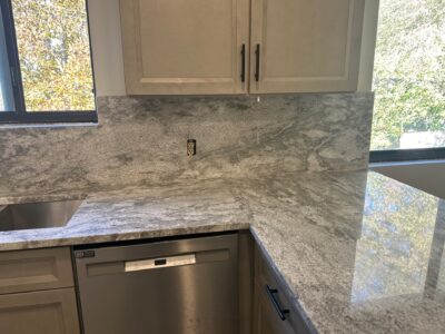 18-Nov 11 2024 08_09pm-KTmA Granite kitchen countertop with integrated backsplash, modern cabinetry, and stainless steel dishwasher, showcasing elegant surface texture and design for kitchen remodeling.