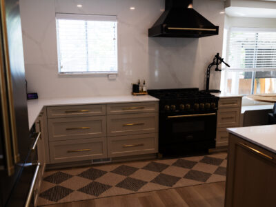 Alyssa4 Modern kitchen design featuring gray cabinetry, a black gas range, and a marble backsplash, emphasizing functional and aesthetic elements of kitchen remodeling.