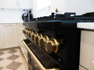 Alyssa9 Kitchen range with gold knobs and black finish, showcasing modern design elements for kitchen remodeling.