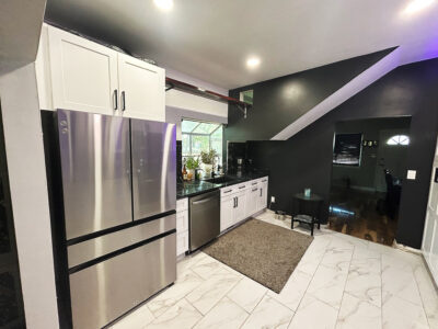 Chris4 Modern kitchen design featuring stainless steel appliances, white cabinetry, and sleek marble flooring, illustrating a stylish remodeling project by Miss K Kitchen and Bath Remodels.