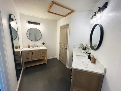 Kristen3 Modern bathroom design featuring dual vanities, round mirrors, and stylish fixtures, highlighting a clean aesthetic ideal for home remodeling projects.