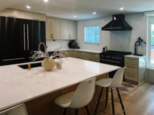 Modern kitchen renovation featuring a spacious island, sleek black appliances, and stylish decor, showcasing Miss K Kitchen and Bath Remodels' craftsmanship and design expertise.