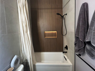 Natale1 Modern bathroom design featuring a white bathtub, textured wood accent wall, and sleek fixtures, illustrating a stylish and functional space for remodeling.