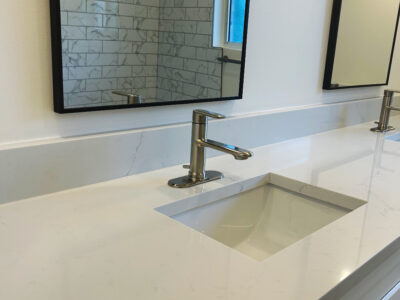 Zack3 Modern bathroom countertop with integrated sink, sleek faucet, and minimalist design, showcasing light-colored stone surface and contemporary mirrors, reflecting the essence of upscale bathroom remodeling.