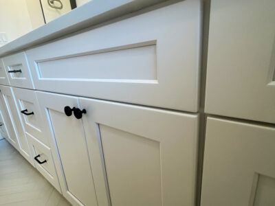 Zack6 White kitchen cabinetry with modern black hardware, showcasing clean lines and a sleek design, relevant for kitchen remodeling discussions.